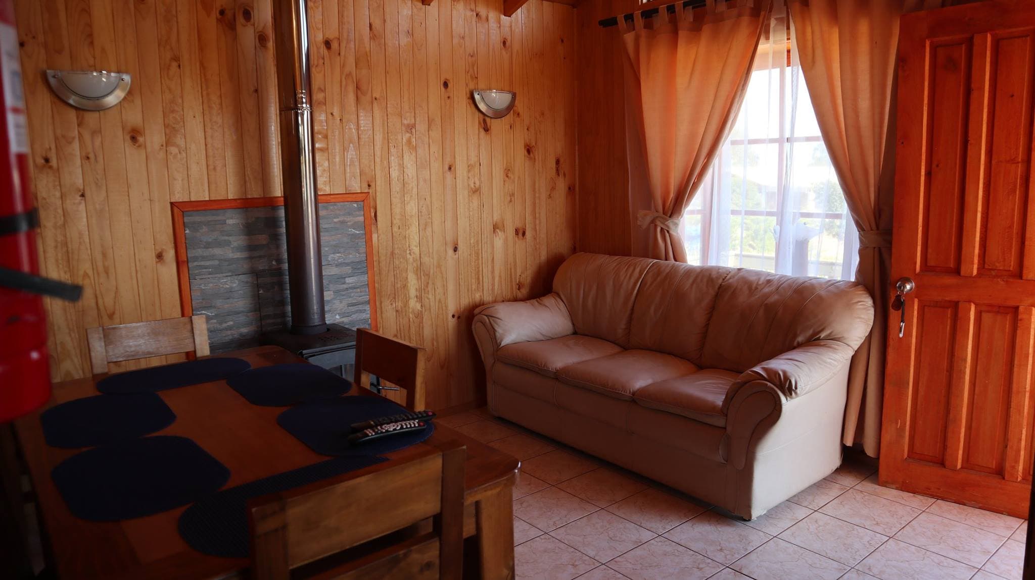 Living de la cabaña con estufa a leña